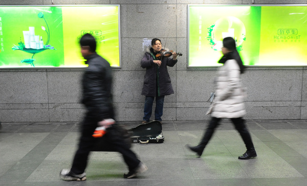 陈惠芳在地下通道拉小提琴卖艺